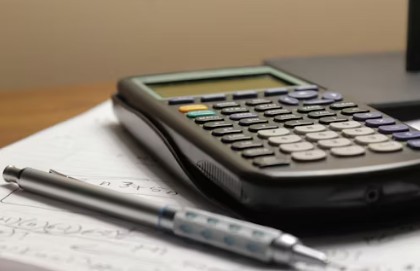 "상가 양도양수 시 권리금 및 순수익을 계산하는 계산기와 필기구 이미지"