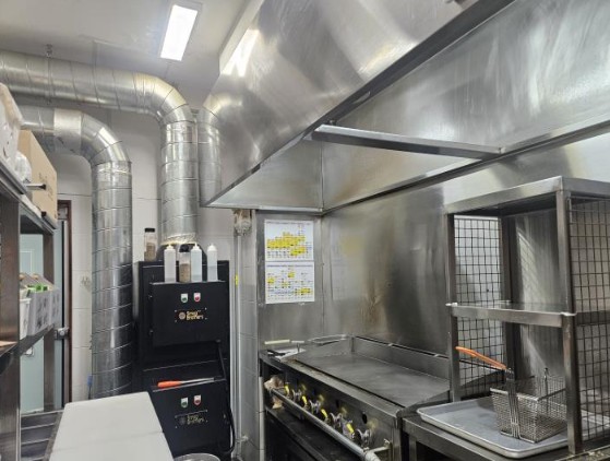안양 프랭크버거 인수 매장의 청결한 주방 내부 전경. 대형 덕트 시설과 조리 기구, 스테인리스 집기들이 깔끔하게 관리된 모습