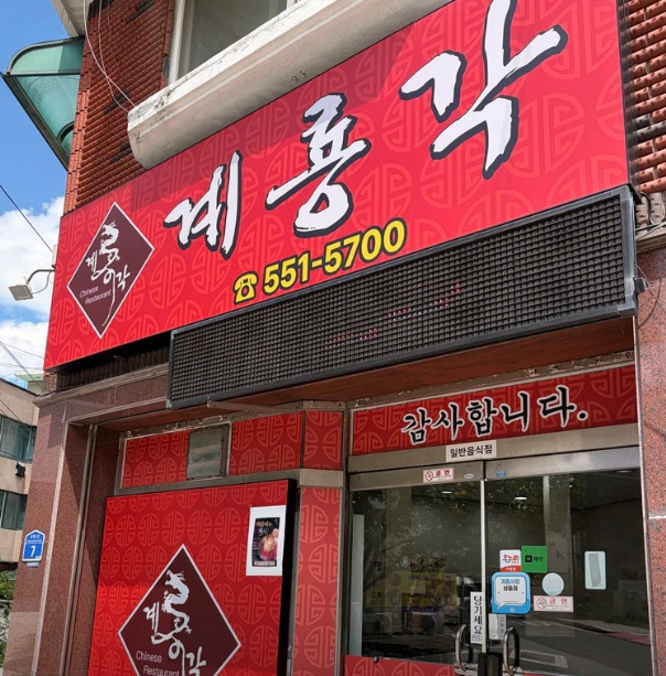 충청남도 계룡시 엄사면 일대에서 안정적인 매출을 기록 중인 중식당 **'계룡각 계룡점'**의 매장 전경. 빨간색 간판과 출입문에 부착된 스티커들을 통해 성업 중임을 확인할 수 있으며, 계룡시 중식당 창업을 희망하는 예비 창업자에게 추천하는 양도양수 매물 정보 이미지입니다.